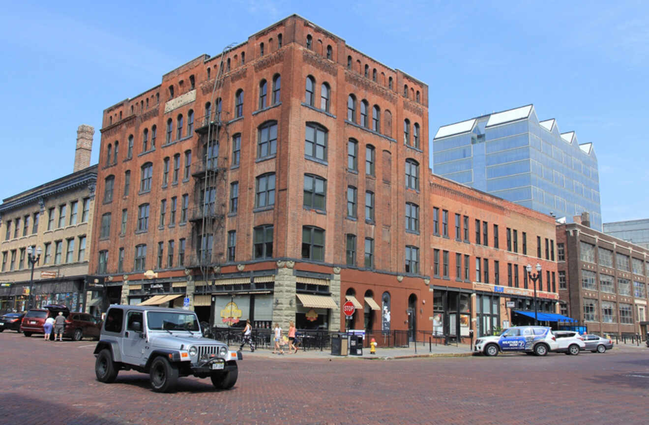 A historic brick building in Omaha's Old Market district, with a jeep and other cars parked on the street