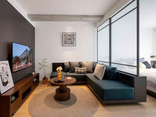 A contemporary living area with a sectional sofa, a coffee table, and a wall-mounted TV.