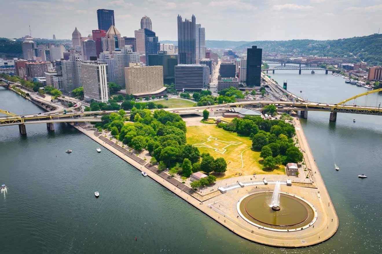 Elevated view of downtown Pittsburgh showcasing the Point State Park fountain, the confluence of rivers, and multiple yellow bridges