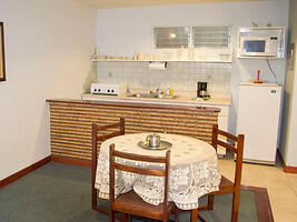 A small kitchen with a dining table and basic appliances.