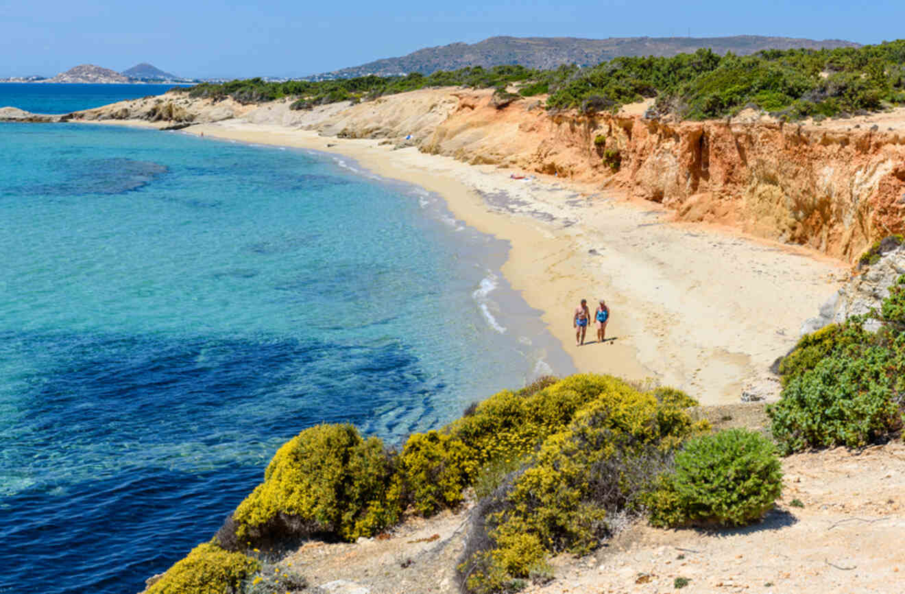 A beautiful beach with clear turquoise waters, sandy shores, and rocky cliffs, perfect for a serene walk.