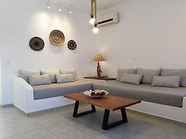 A living room with built-in sofas, wooden coffee table, and wall decor in a minimalist style.