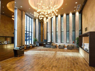 A grand hotel lobby with high ceilings, elegant lighting, and comfortable seating areas