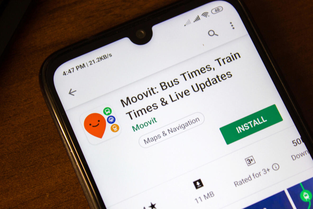 Smartphone screen displaying the Moovit app page on the Google Play Store, offering bus times, train times, and live updates with an install button visible.