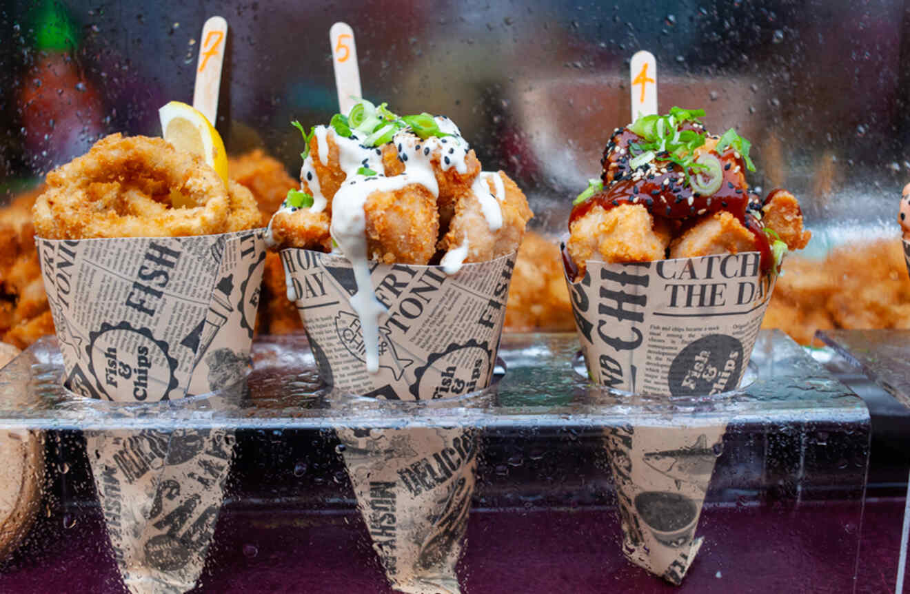 Three cones filled with different styles of fried fish, labeled with numbers at a food stall in London, UK.