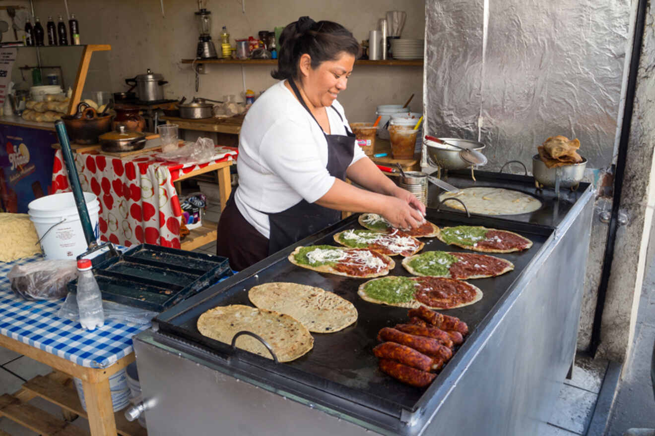 Woman preparing traditional Mexican tortillas topped with various sauces at a street food stall in Mexico City, Mexico.