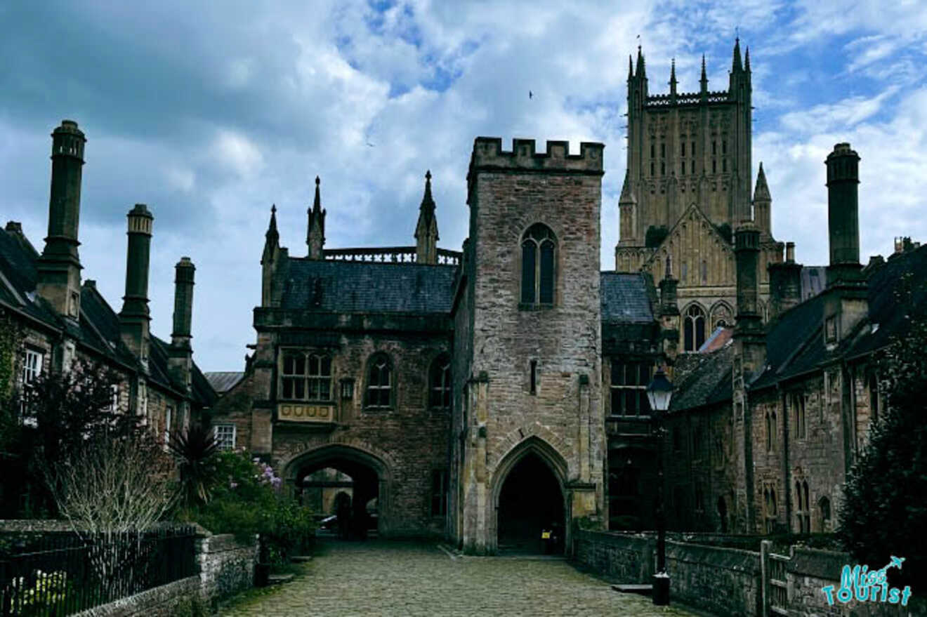 The entrance to Penniless Porch, a historic stone gateway, with Wells Cathedral visible in the background.