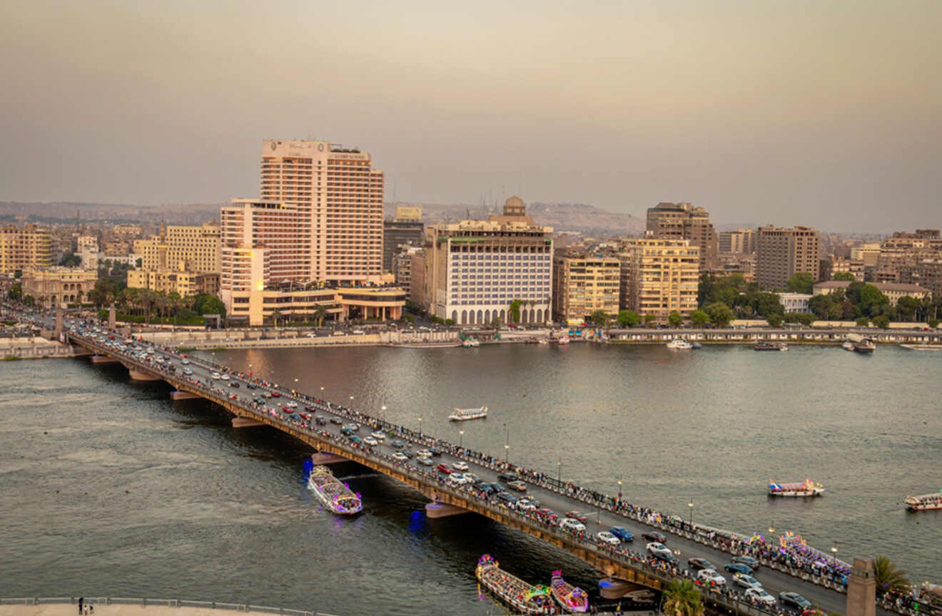 Cityscape of Cairo featuring a busy bridge over the Nile and surrounding buildings.