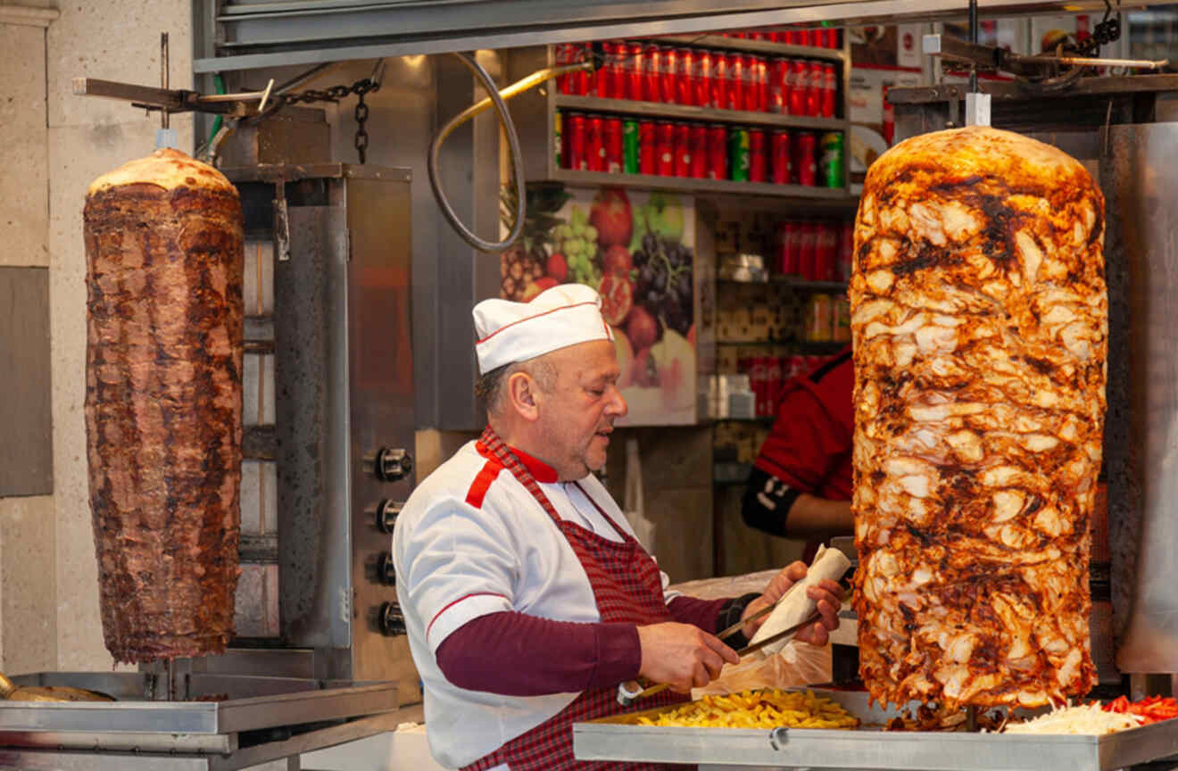 Chef slicing meat from a vertical rotisserie at a food stall in Istanbul, Turkey.