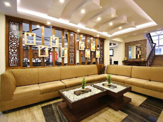 A luxurious lobby area with elegant brown sofas, artistic wooden partitions, and stylish ceiling design.