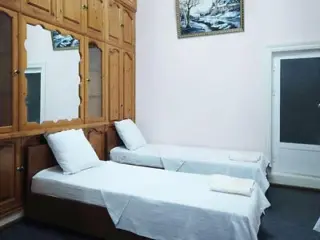 A minimalist bedroom with twin beds, wooden cabinetry, and simple, clean decor.