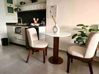 Compact kitchen area with a small dining table and two chairs.