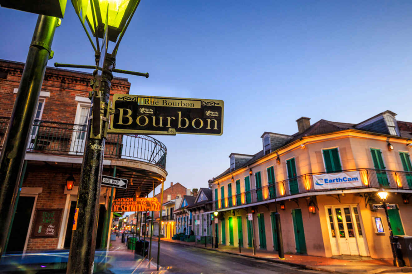 Street view of Bourbon Street in New Orleans at dusk, featuring buildings with balconies and a street sign reading "Bourbon.