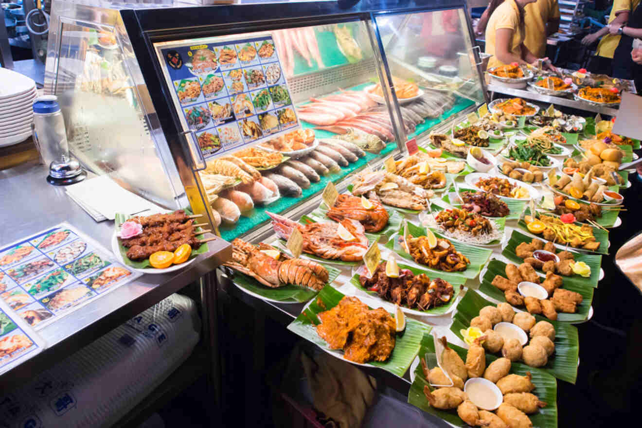 Display of various seafood dishes at a food stall in Singapore.