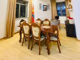 An elegant dining room featuring a wooden table with ornate chairs and warm lighting.