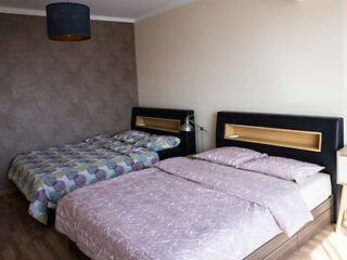 A spacious bedroom with two double beds, modern decor, and ample natural light.