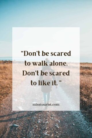 Image of a person walking alone on a path with a wide landscape view, with the quote "Don’t be scared to walk alone. Don’t be scared to like it." and the website "misstourist.com" displayed on the image.