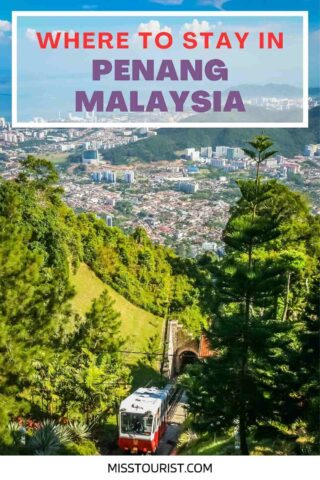 A scenic view of Penang, Malaysia, with lush greenery, urban buildings in the background, and a funicular train ascending a hill. The text reads "Where to Stay in Penang, Malaysia.