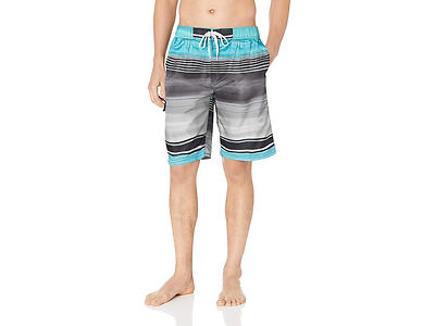 A person standing barefoot wearing multicolored board shorts, featuring horizontal stripes in shades of blue, gray, and black. Hands in pockets, torso not visible.