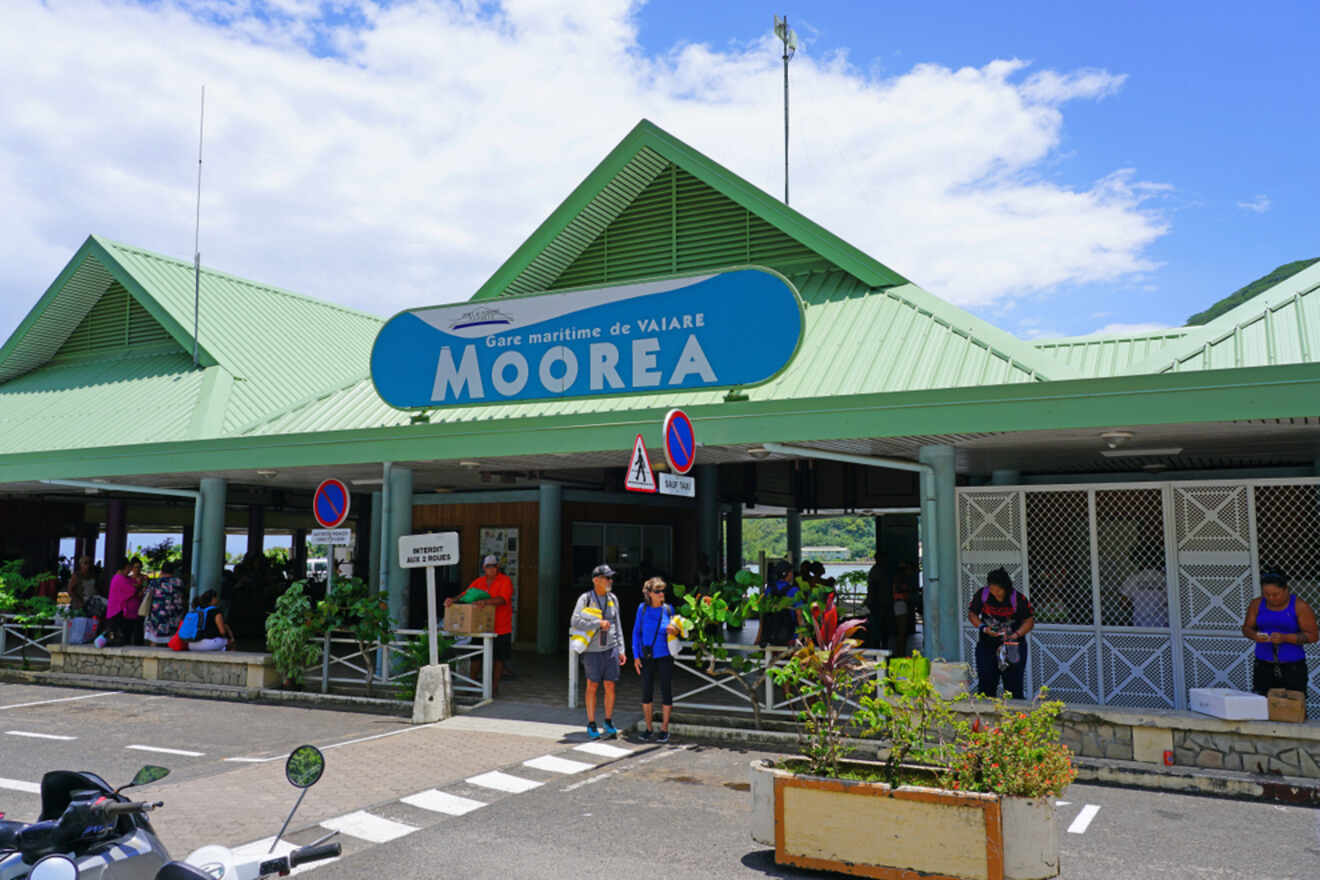 The entrance of Gare maritime de Vaiare in Moorea, with passengers and a sign indicating the ferry terminal.