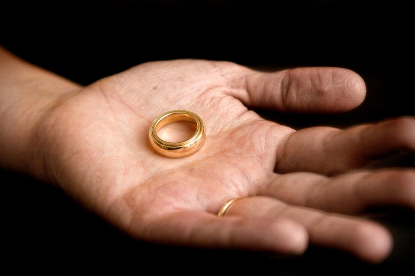 A close-up of an open palm holding a golden ring, with a soft focus on the hand and the ring.