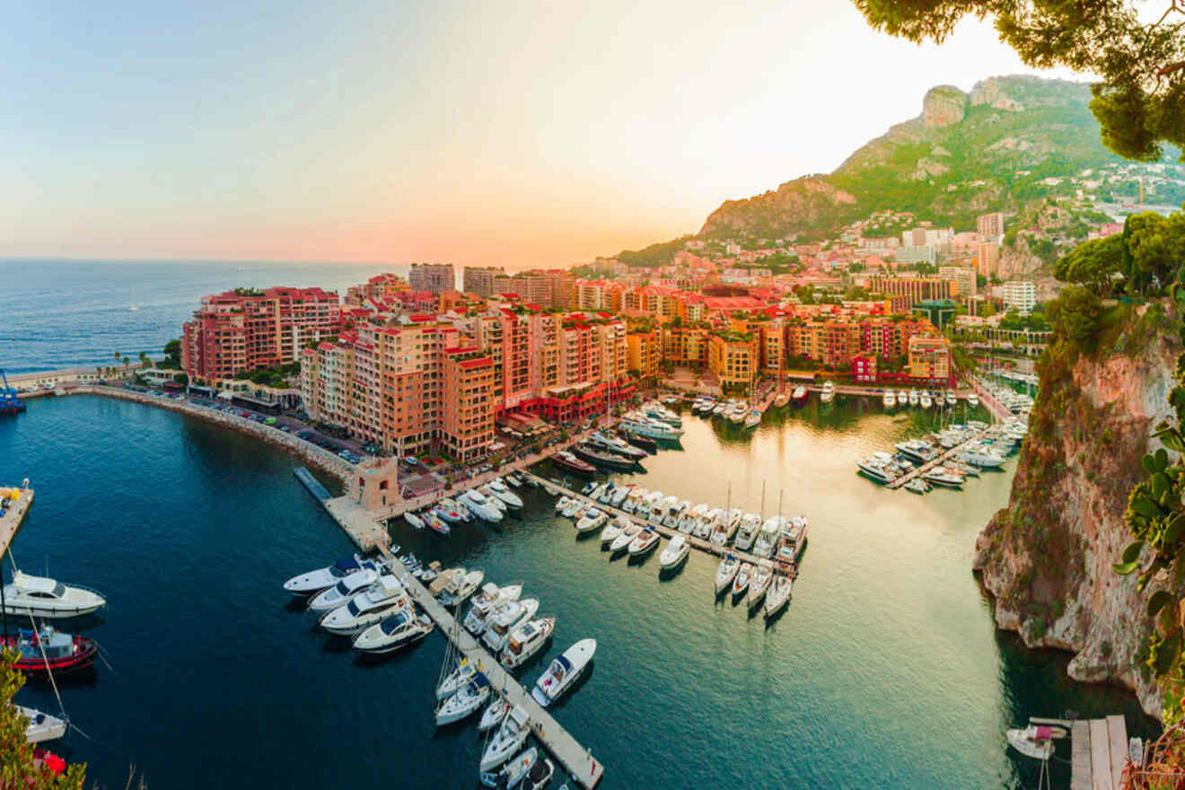 An aerial view of Port Fontvieille in Monaco at sunset, showcasing a marina filled with yachts and surrounded by colorful buildings.