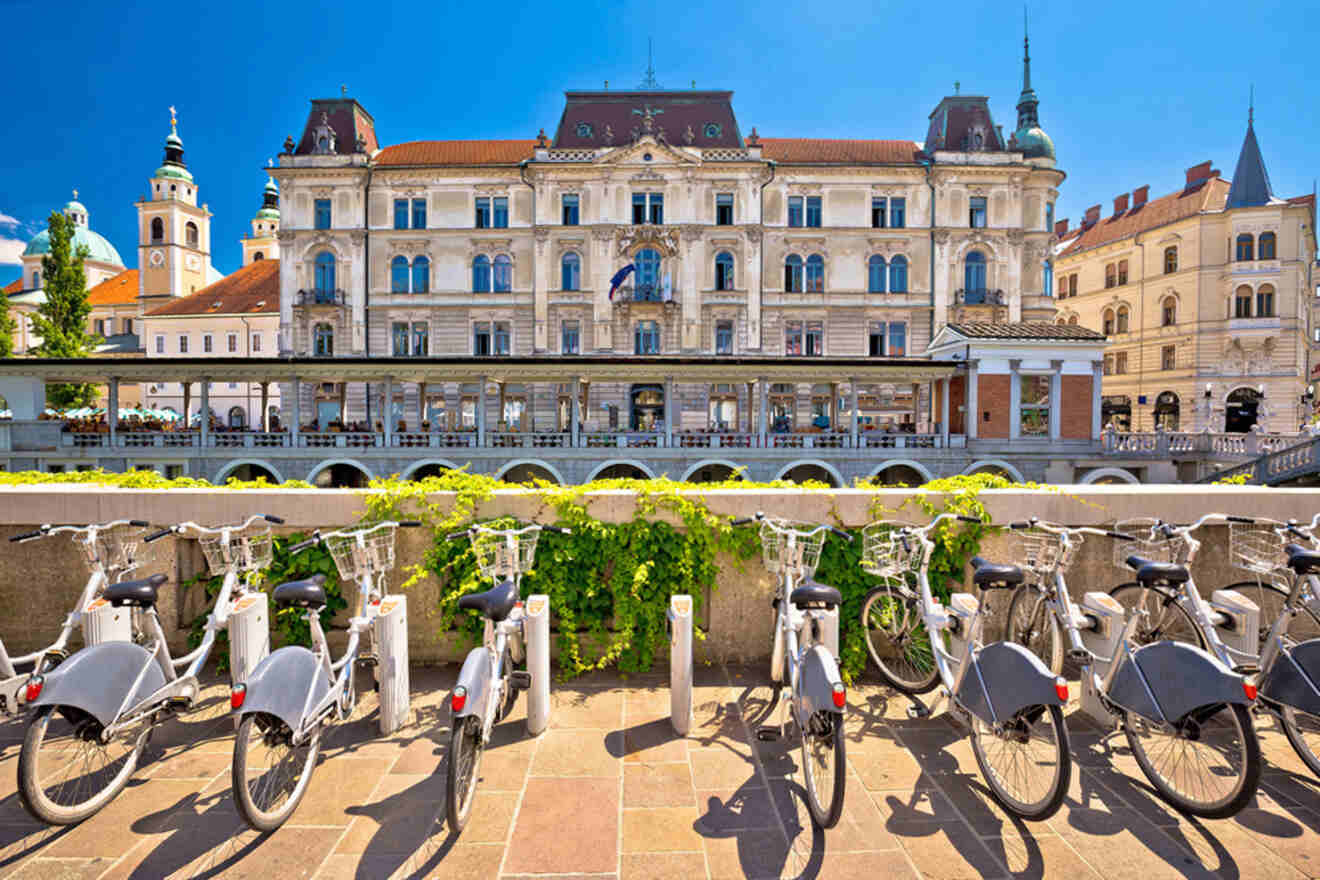 Row of bicycles parked in front of a historic building on a sunny day.
