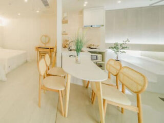 Bright, modern studio apartment with light-colored furniture and an open kitchen.