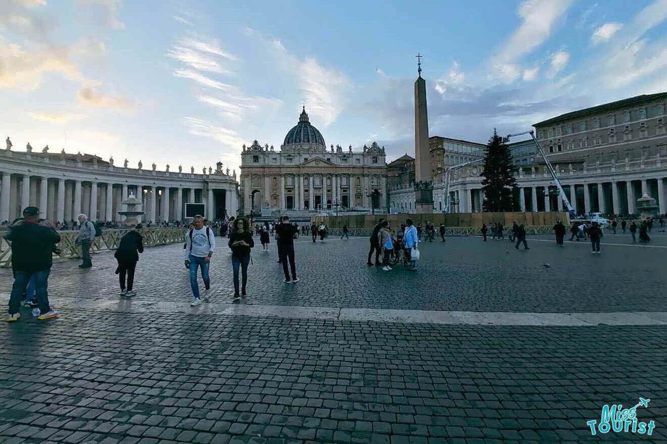 St. Peter's Basilica and St. Peter's Square Obelisk in Vatican City, with visitors walking around the vast square.