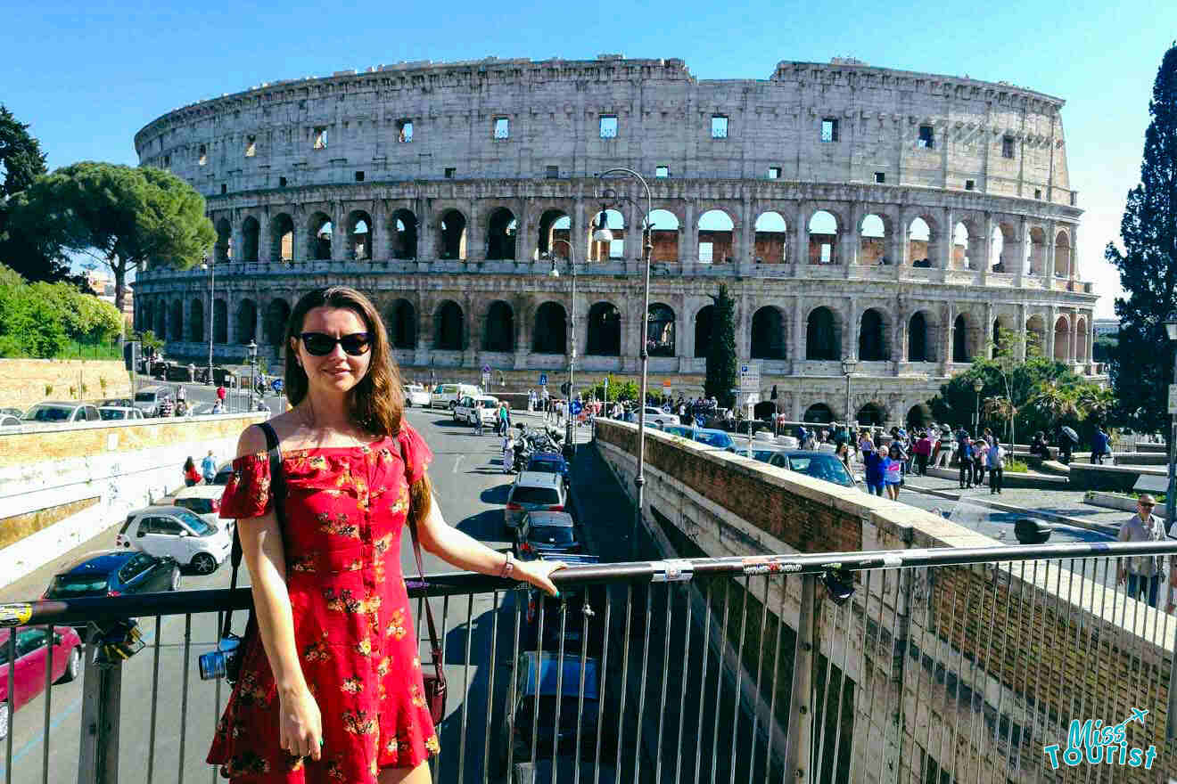 The writer of the post posing in front of the Colosseum in Rome, with bustling traffic and tourists in the background.