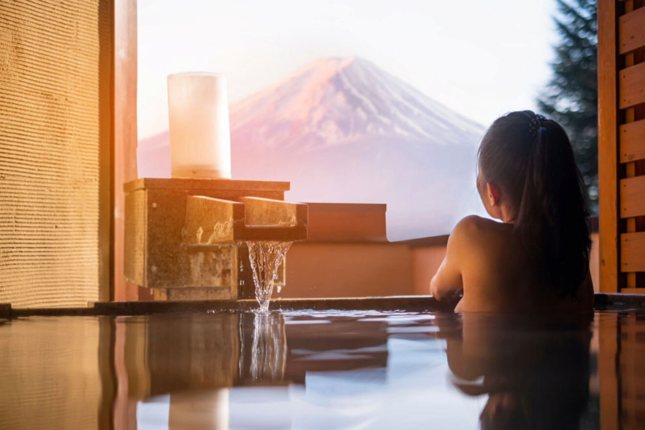 A woman relaxes in a private onsen with a stunning view of Mount Fuji in the background.