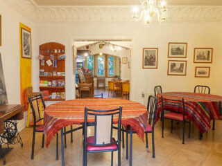 Dining area with round tables covered in colorful striped tablecloths, set in a cozy, traditional space.