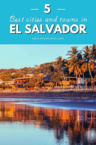 Cover image with the title "5 Best cities and towns in El Salvador" from misstourist.com, featuring a beachside town with houses and palm trees reflecting on the water during sunset.