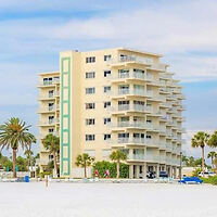 A mid-rise beachfront hotel with multiple balconies