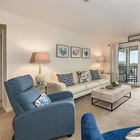 A cozy living room with a white couch adorned with blue and white cushions