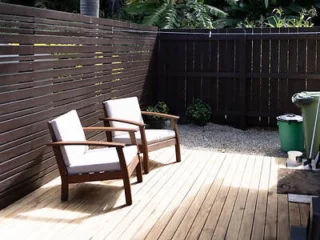 Private wooden deck with two chairs in a secluded area at a villa