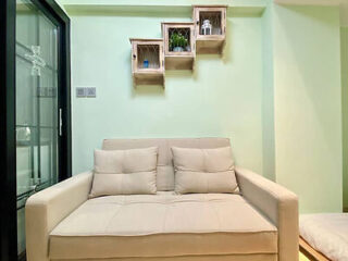 A cozy Japanese-style room with a light beige loveseat against a soft green wall