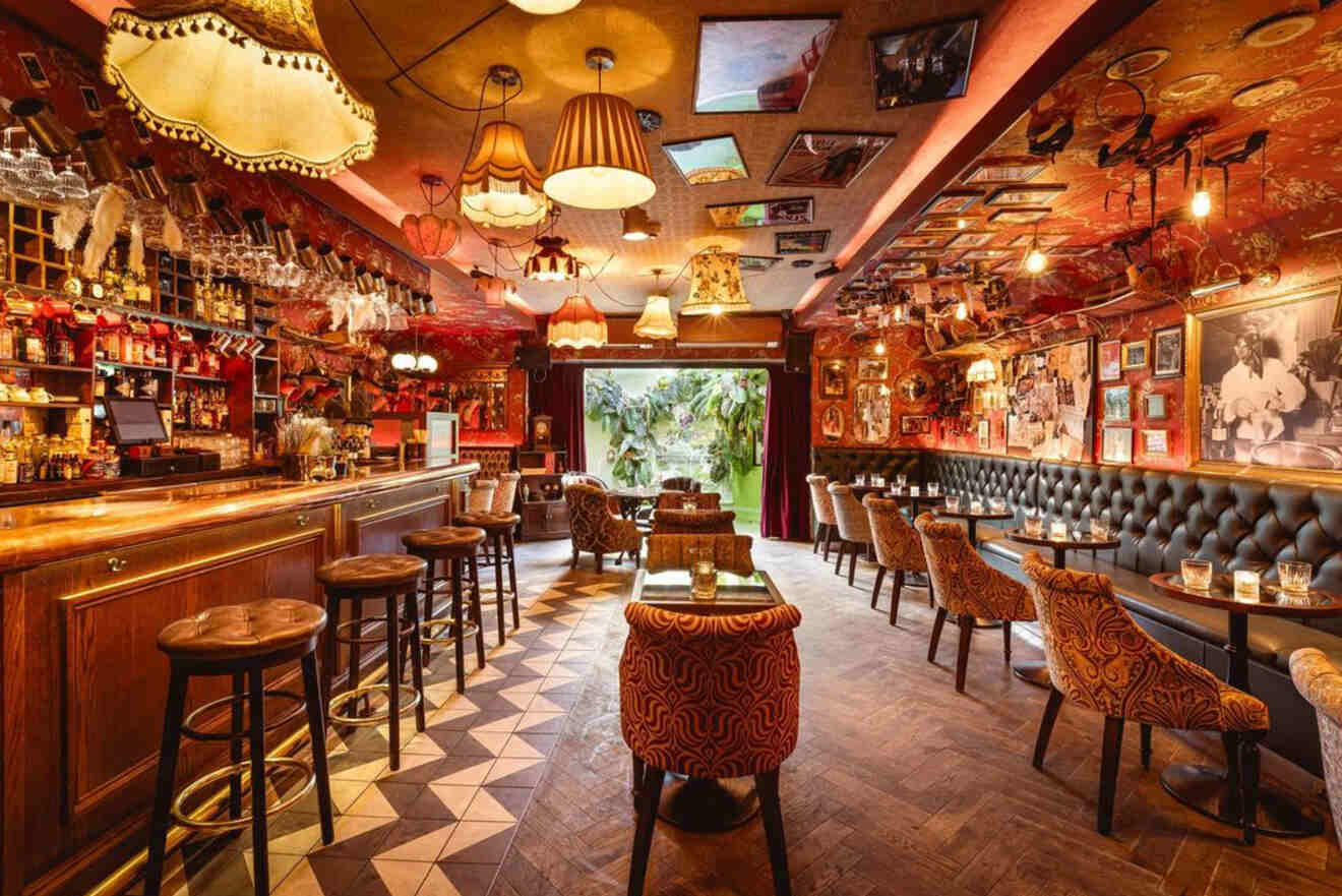 A vibrant, eclectic bar with vintage lampshades hanging from the ceiling, plush chairs, and quirky wall décor, exuding a whimsical atmosphere.