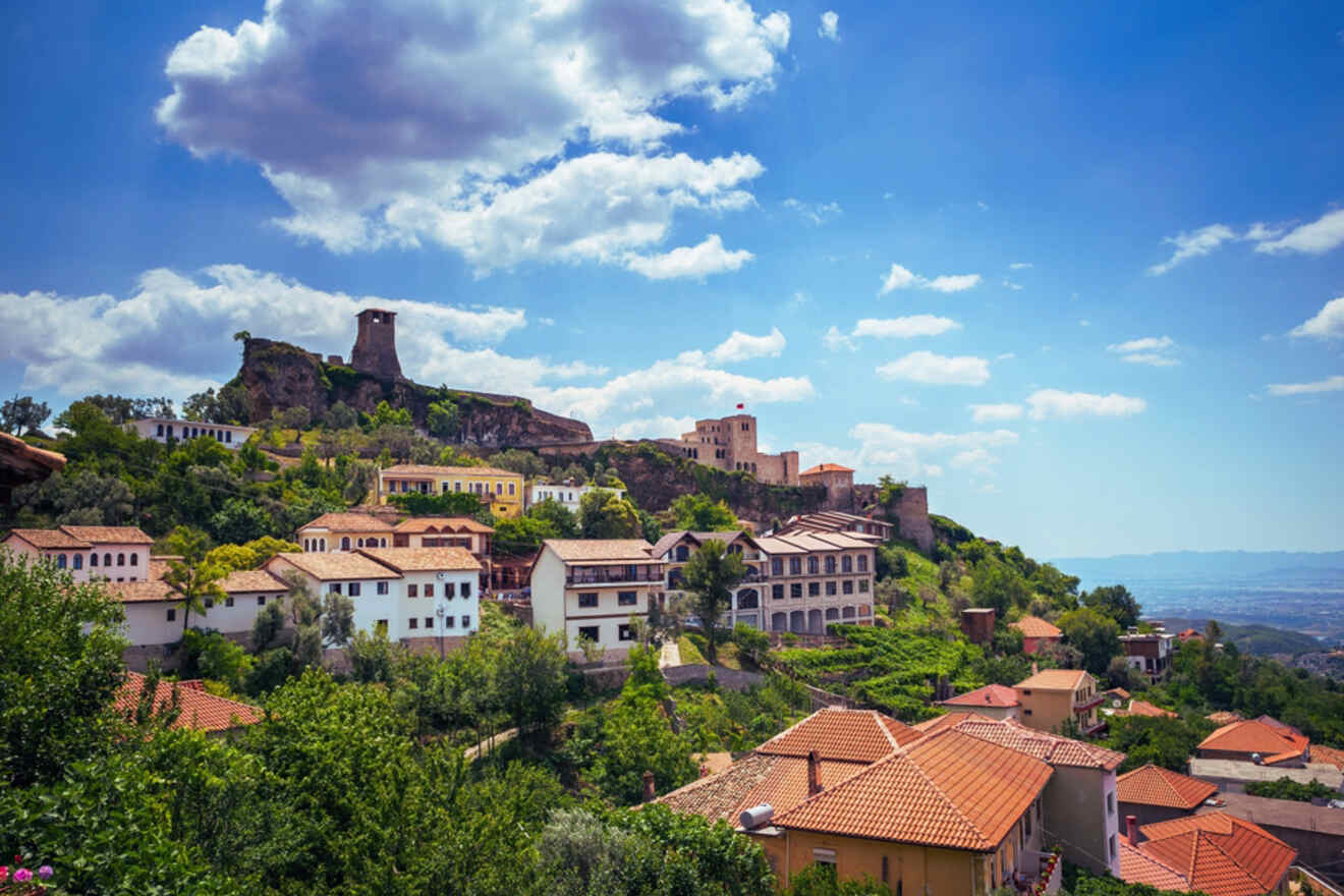 The old town of Tirana, Albania, with a mix of historic and modern buildings under a bright, sunny sky, providing a scenic cityscape with mountains in the distance.