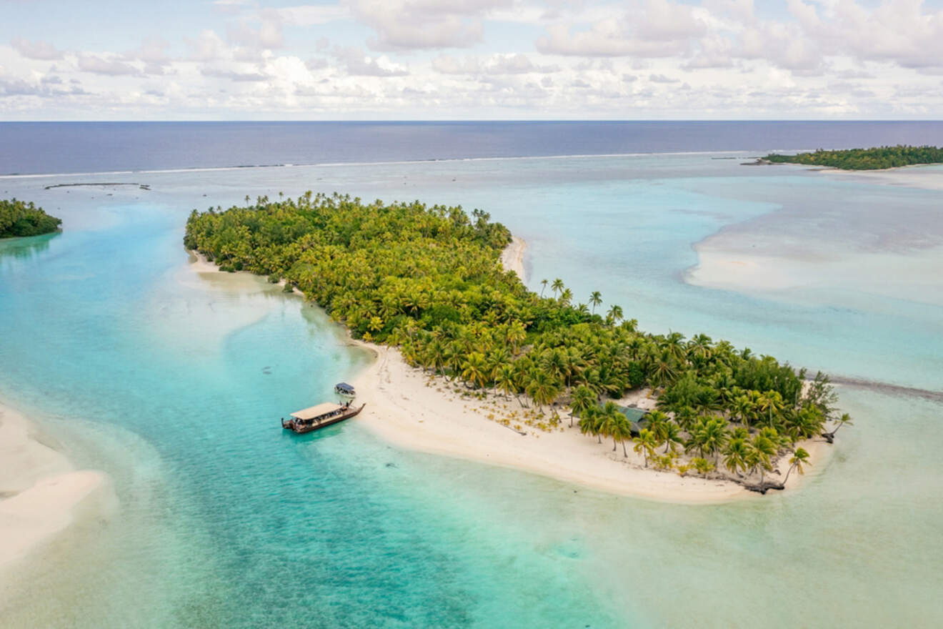 Aerial view of One Foot Island with clear turquoise water, white sand, and dense palm trees in Aitutaki, Cook Islands