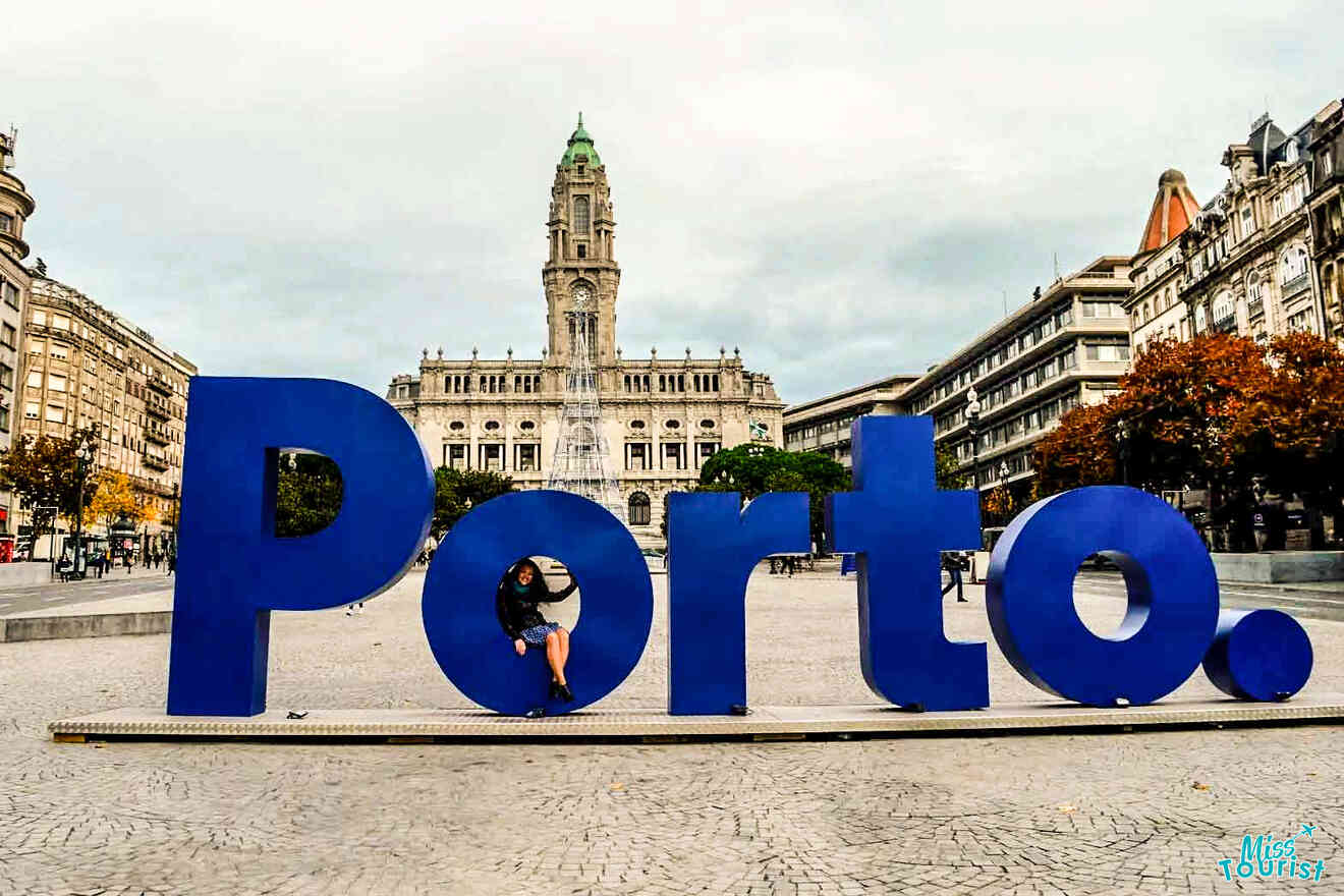 In a city square in Portugal, large blue letters spell 