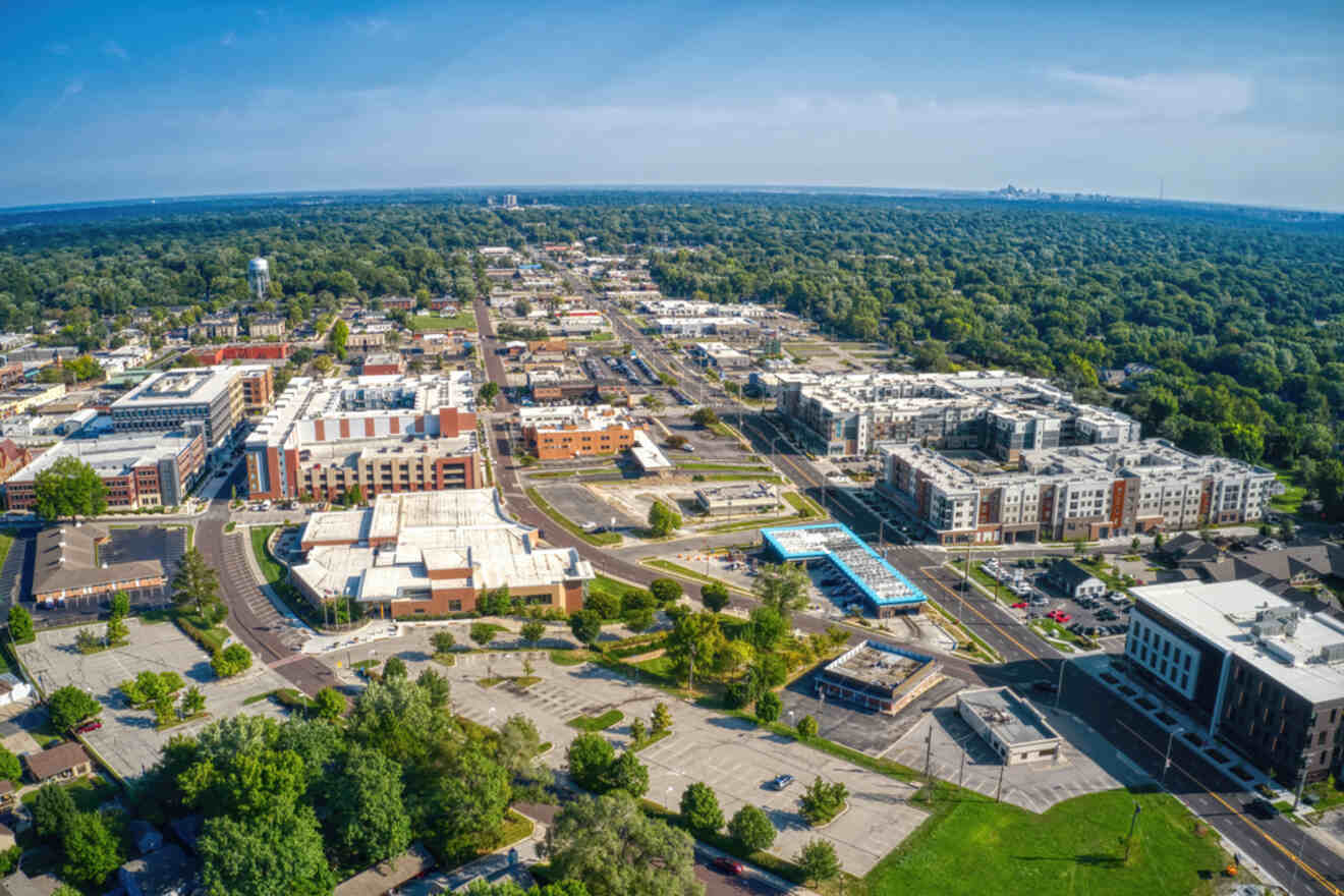 Aerial view of Overland Park, Kansas, showing a mix of residential and commercial buildings surrounded by trees and roads extending into the distance.