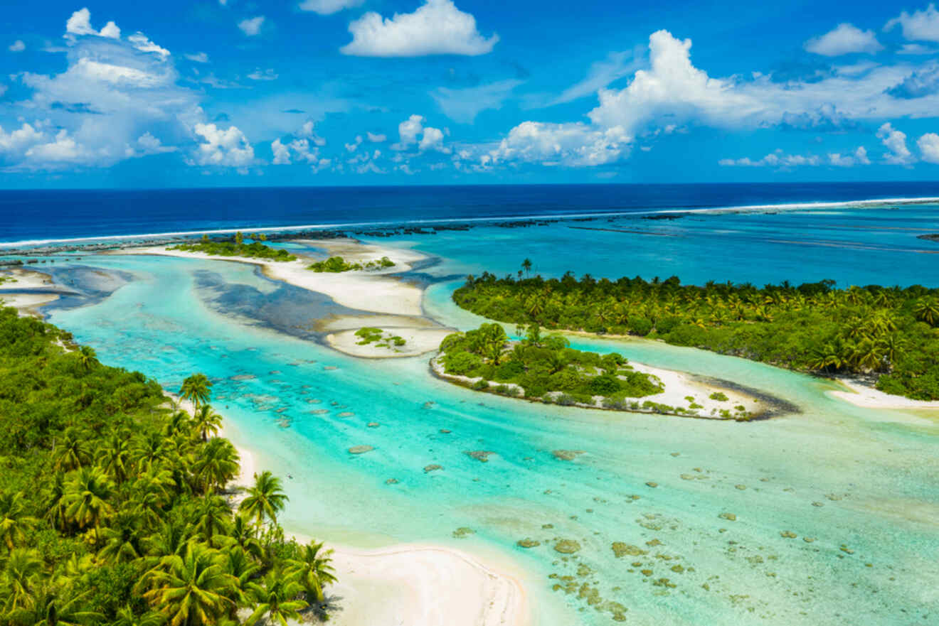 A stunning aerial view of Rangiroa in the Tuamotu Islands, showcasing bright turquoise waters winding through lush green islets, with white sand beaches and coral reefs visible below the surface.