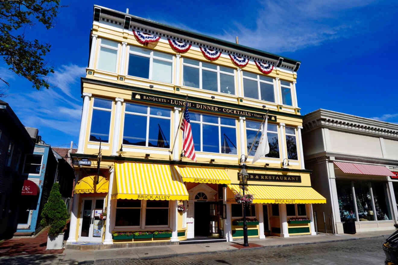 A three-story yellow building with awnings, American flags, and red, white, and blue bunting; it houses a restaurant advertising banquets, lunch, dinner, and cocktails.