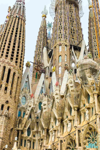 Close-up view of the intricate facade and spires of La Sagrada Família, a large, unfinished Roman Catholic basilica in Barcelona, Spain.