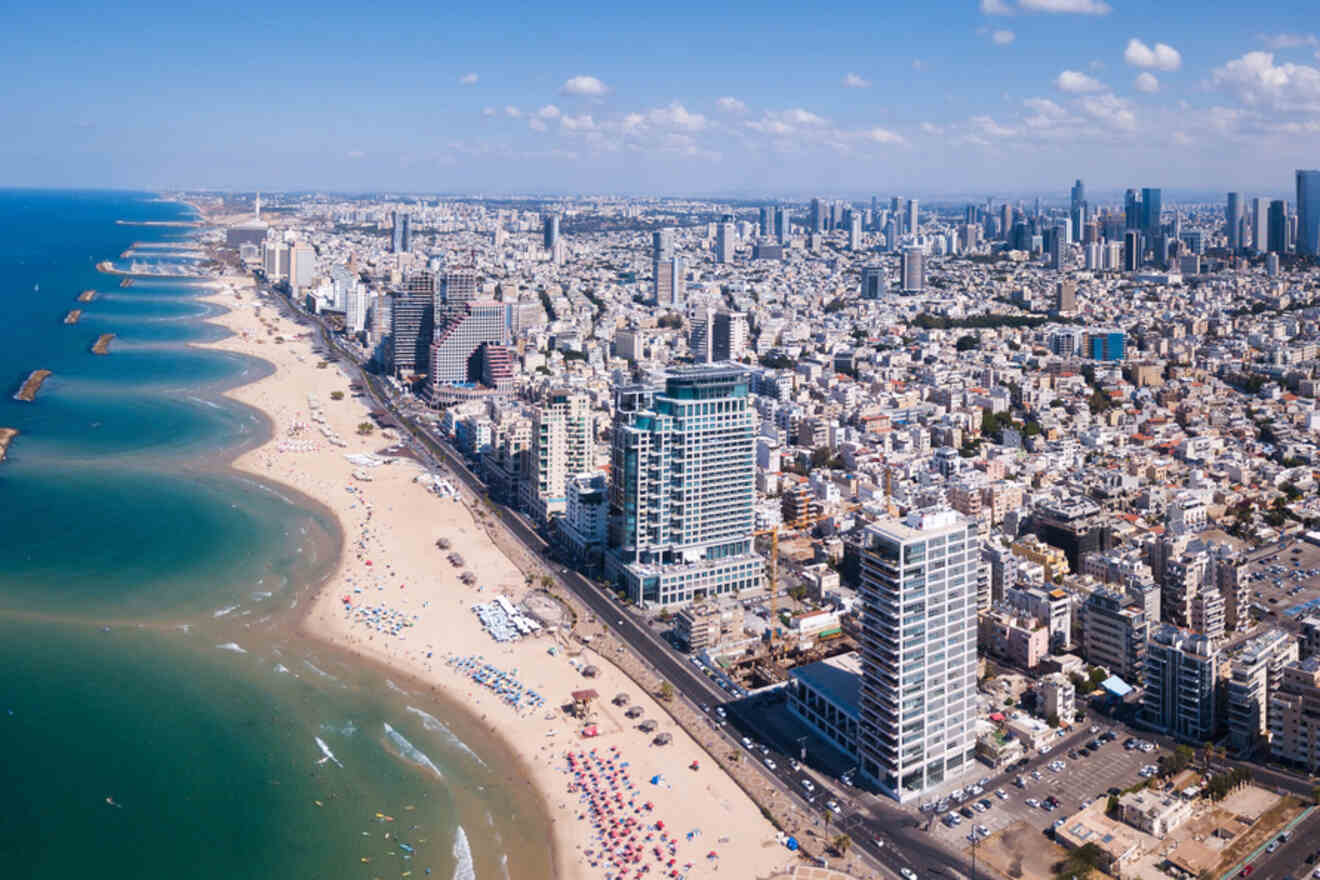 Aerial view of Tel Aviv's expansive beach coastline, with high-rise buildings and the Mediterranean Sea stretching alongside the city.