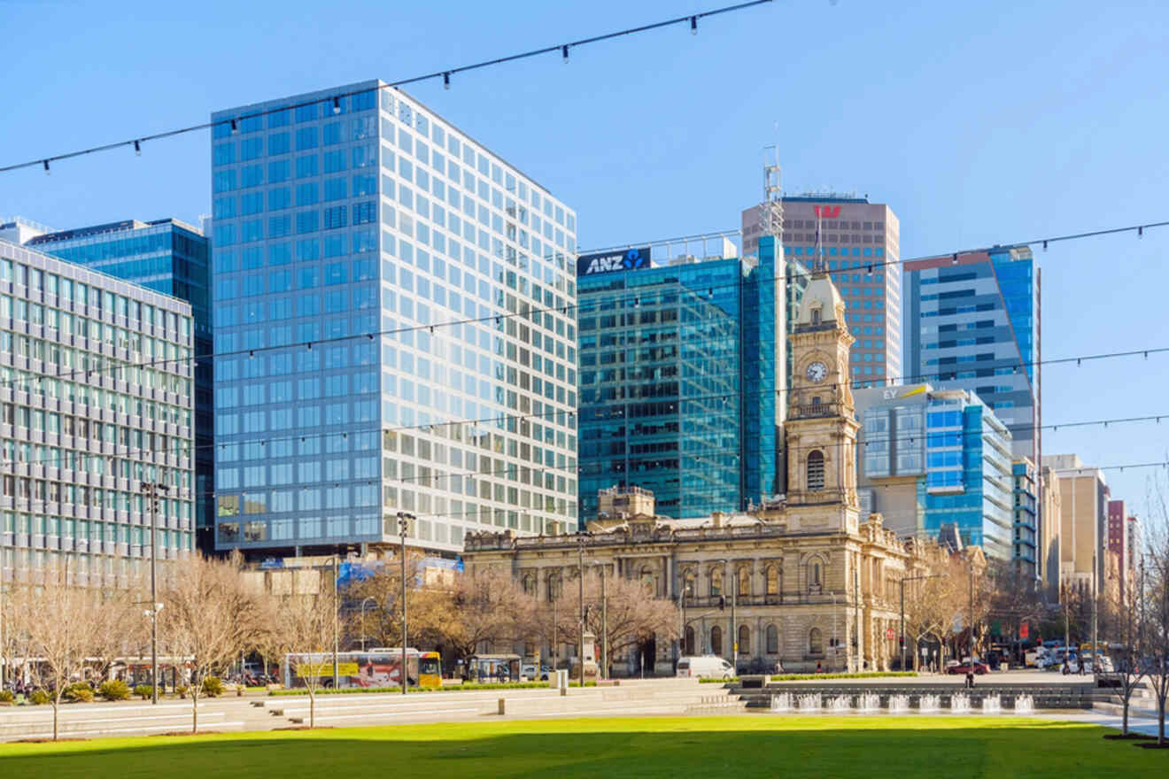 View of Victoria Square in Adelaide showcasing modern skyscrapers and a historic clock tower.