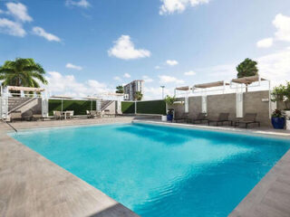 Outdoor swimming pool with lounge chairs and umbrellas on a sunny day.