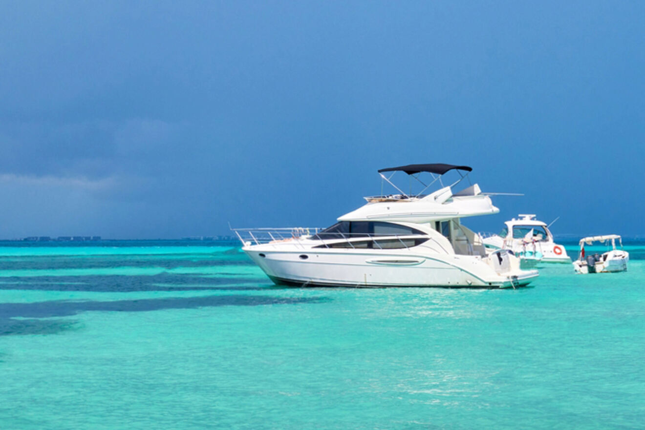 Boats anchored in clear turquoise water under a blue sky.