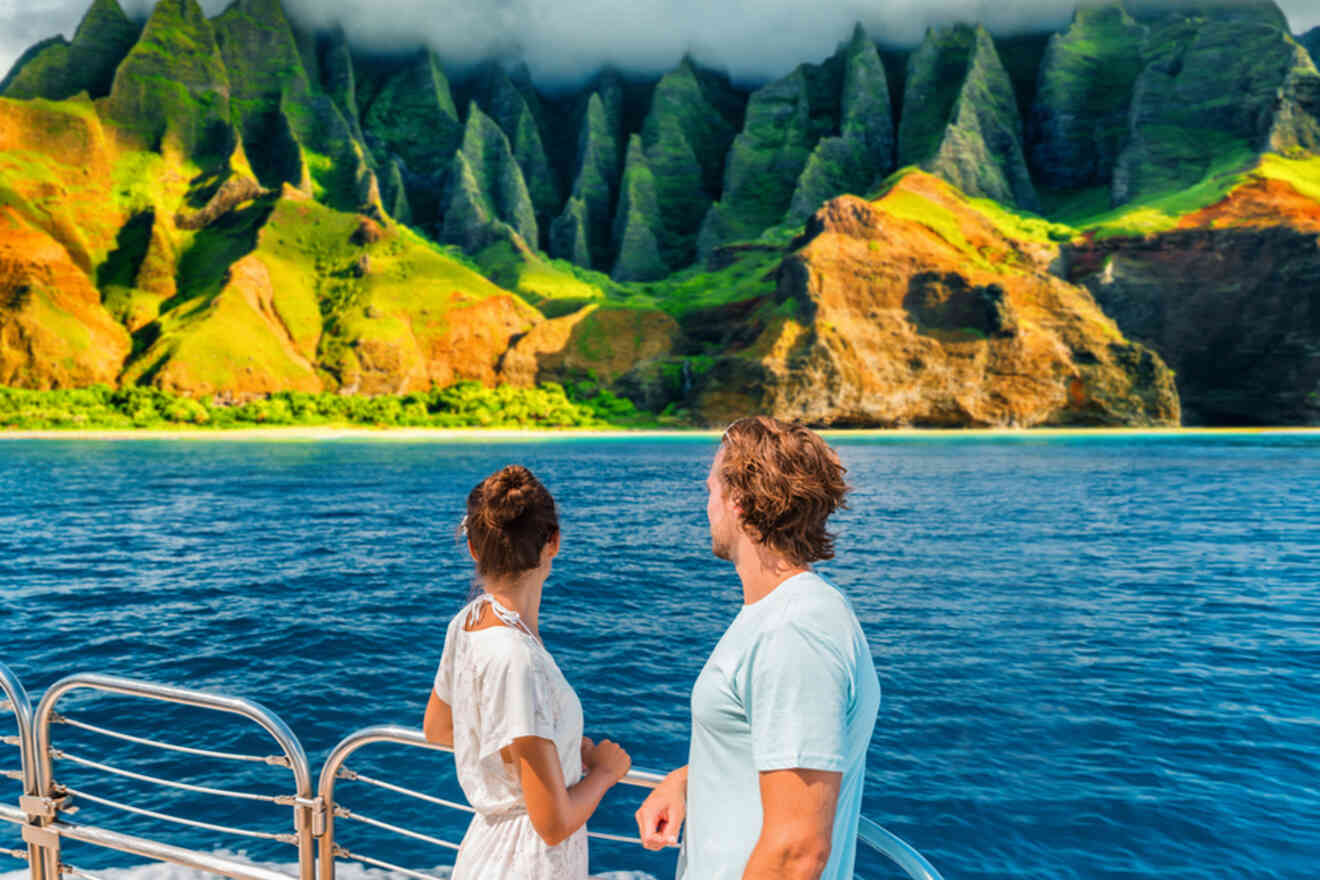 Two people on a boat admire a stunning green and rocky coastline under a cloudy sky.